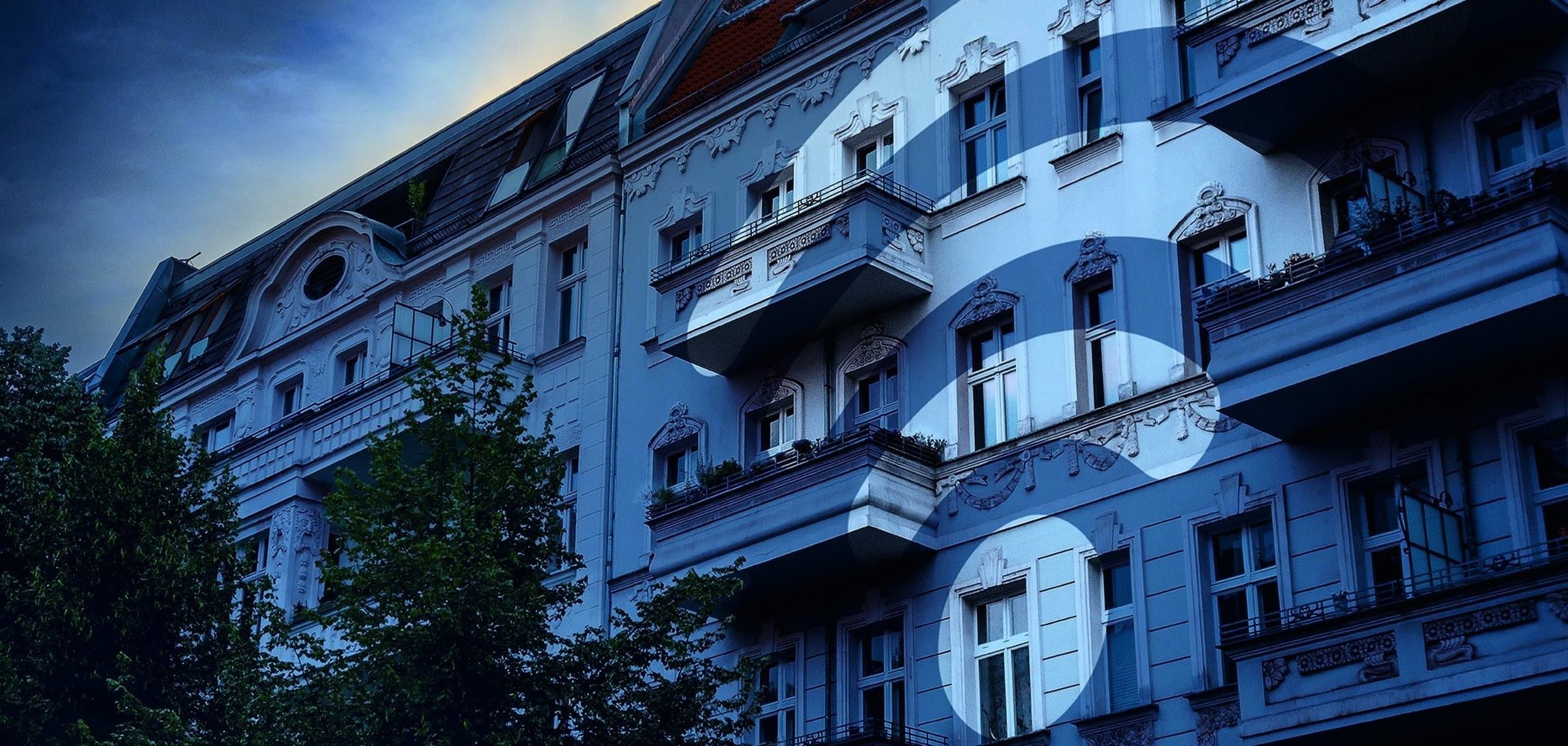 Häuserfront über die ein blauer Filter und ein WLAN-Icon gelegt ist.