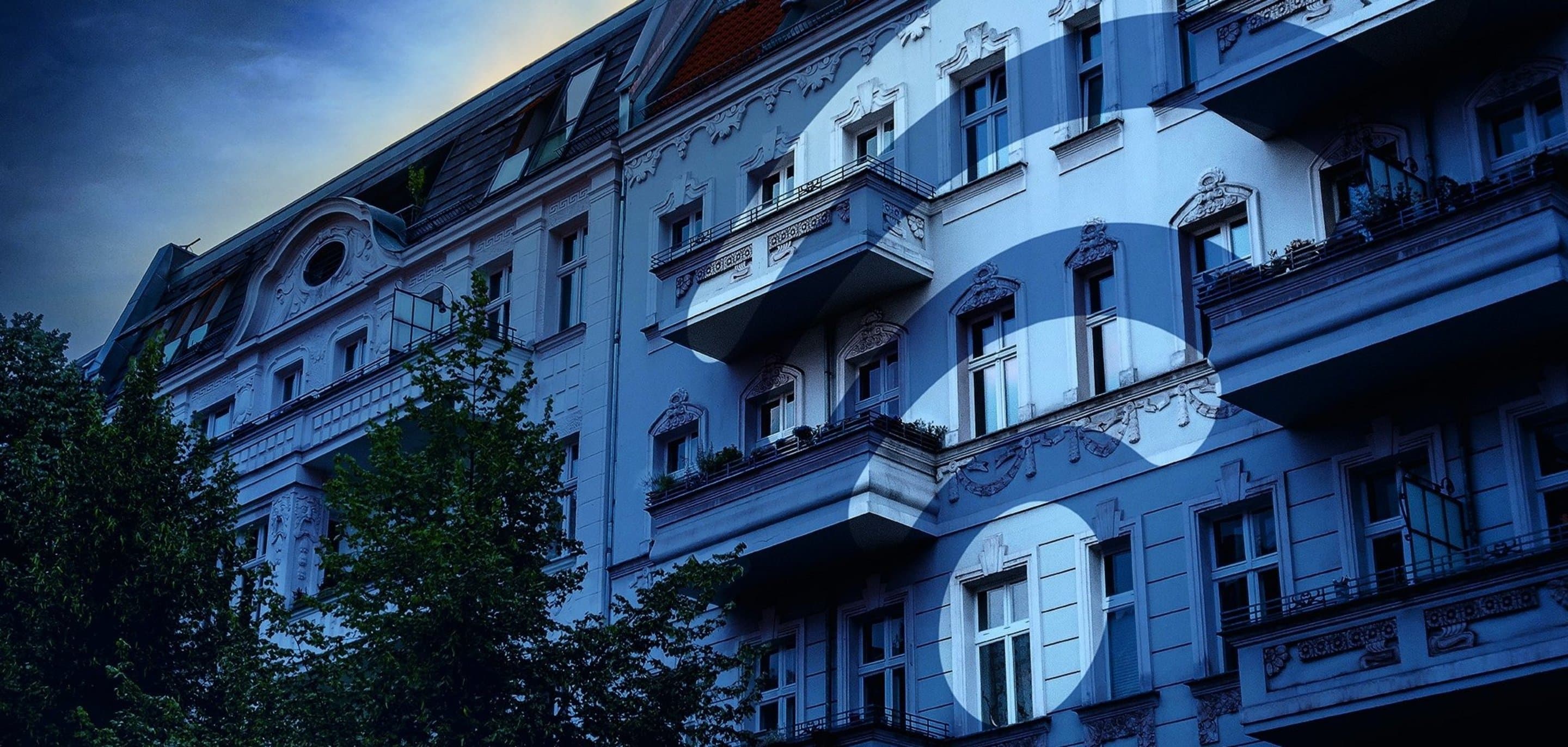 Häuserfront über die ein blauer Filter und ein WLAN-Icon gelegt ist.