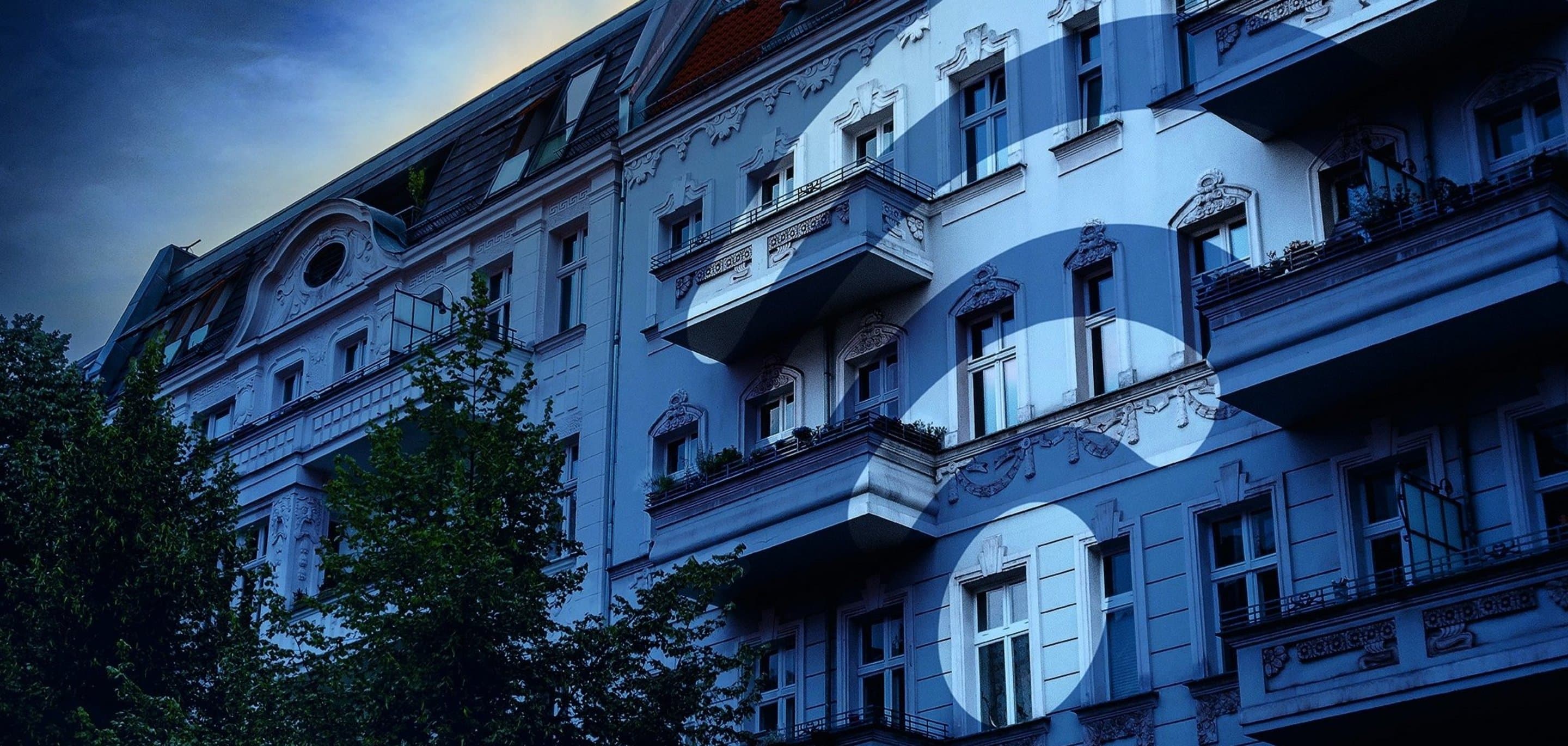 Häuserfront über die ein blauer Filter und ein WLAN-Icon gelegt ist.