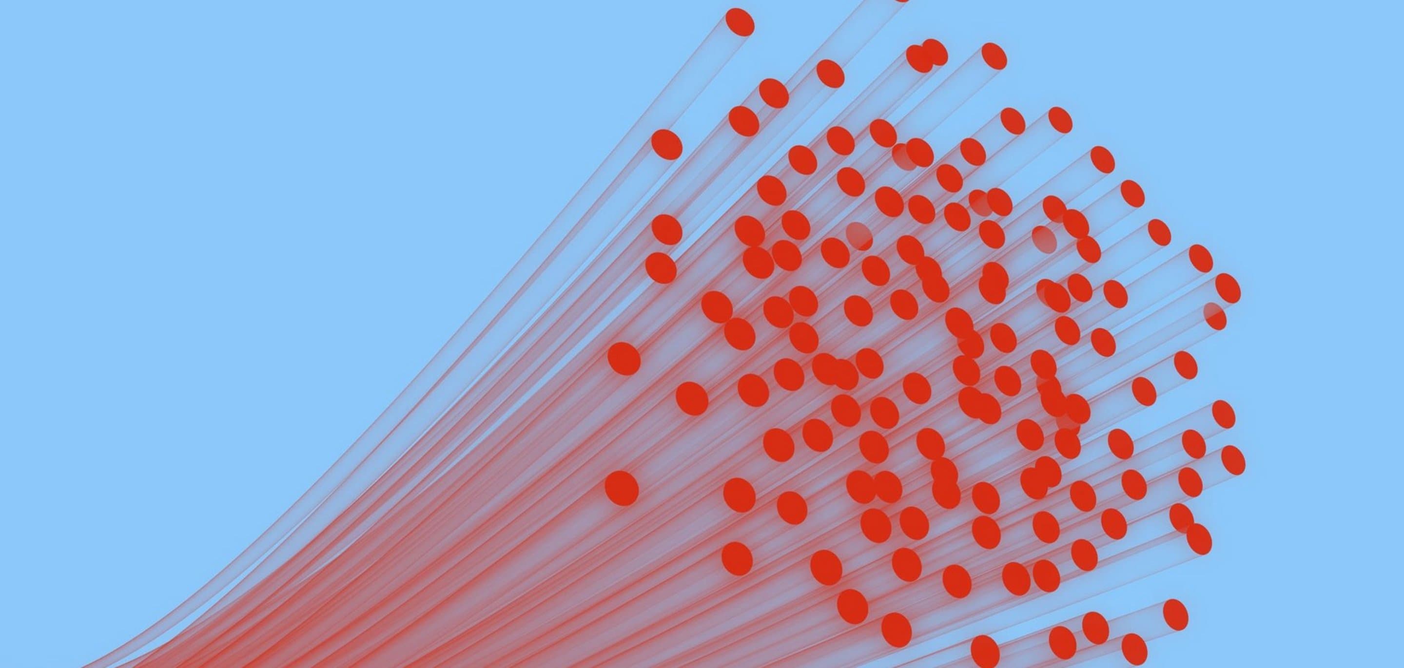 Nahaufnahme von roten Glasfaserkabeln vor hellblauem Hintergrund, die sich fächerförmig ausbreiten.