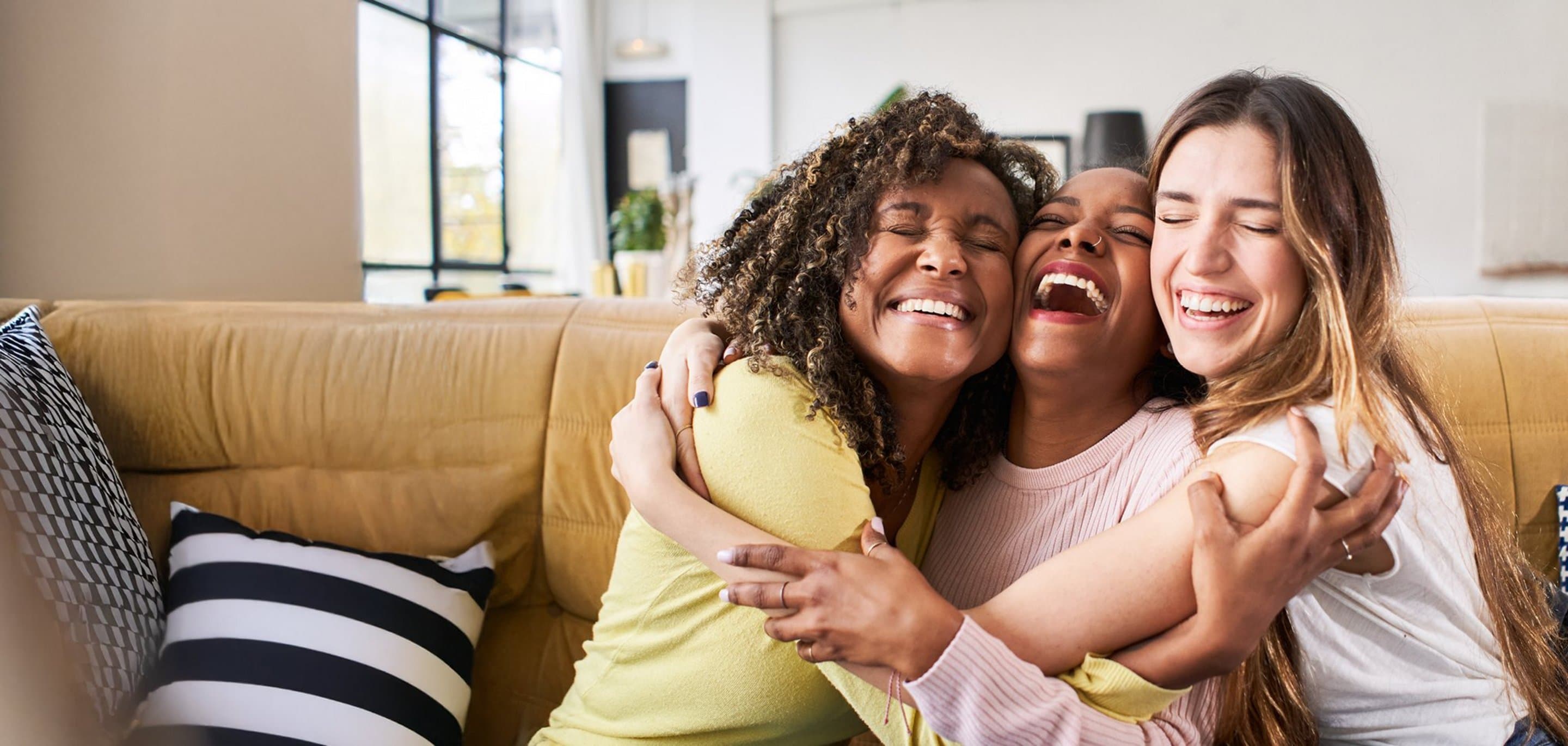 Freunde werben 100 Prämie 3 Frauen sitzen auf der Couch und umarmen sich