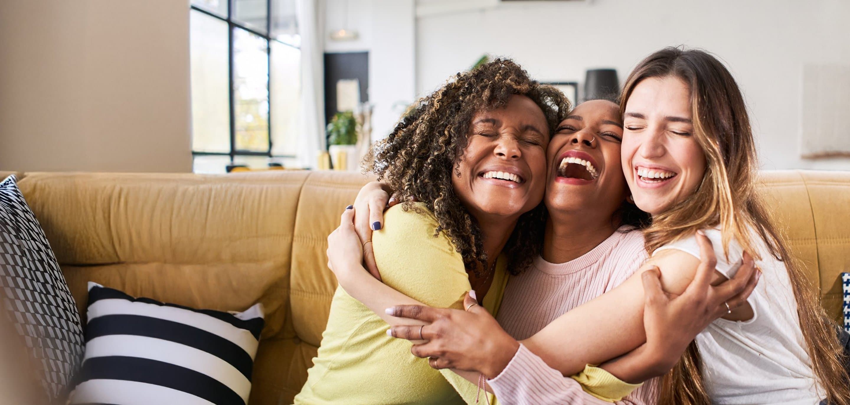 Freunde werben 200 Prämie 3 Frauen sitzen auf der Couch und umarmen sich