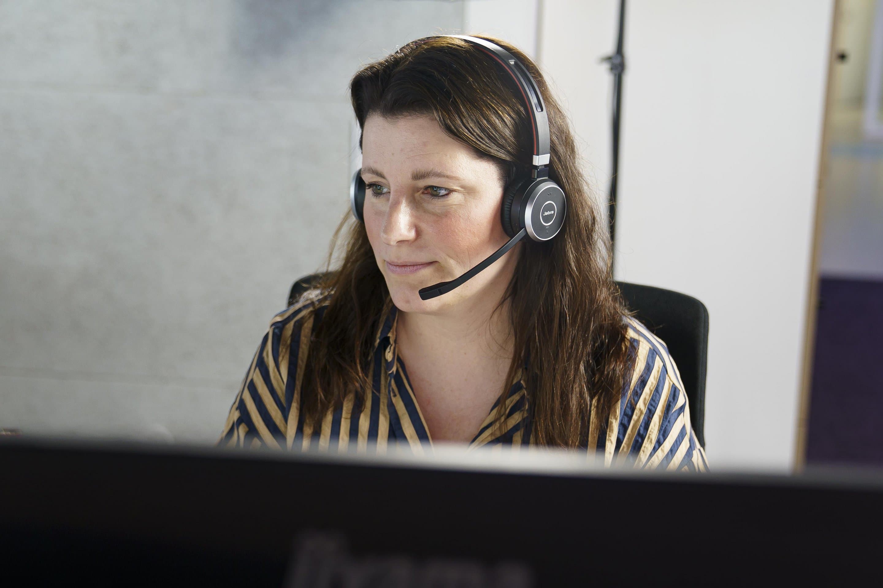 NetCologne, GK Costumer Service Eine Mitarbeiterin von NetCologne sitzt am Bildschirm und telefoniert mit einem Headset.